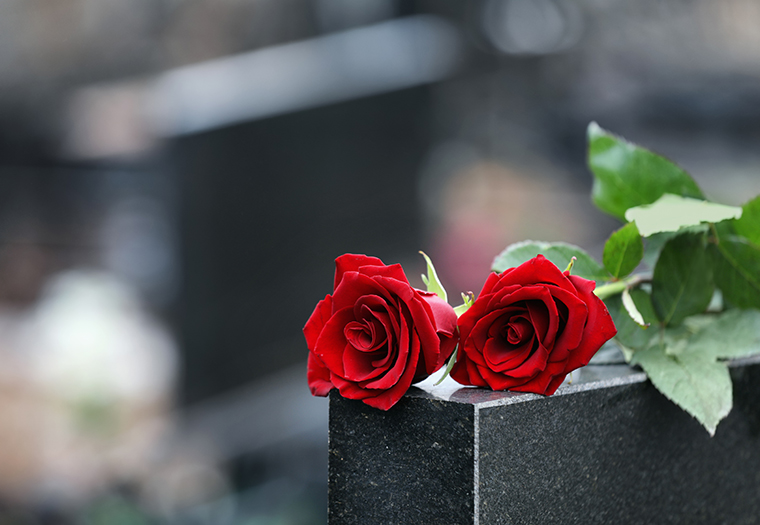 Red,Roses,On,Black,Granite,Tombstone,Outdoors,,Space,For,Text.